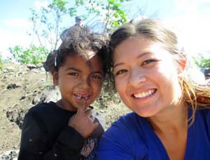 A dirty little girl at the dump with a Spanish student. Charity