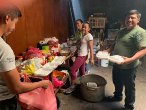 a family preparing packing meals. Charity